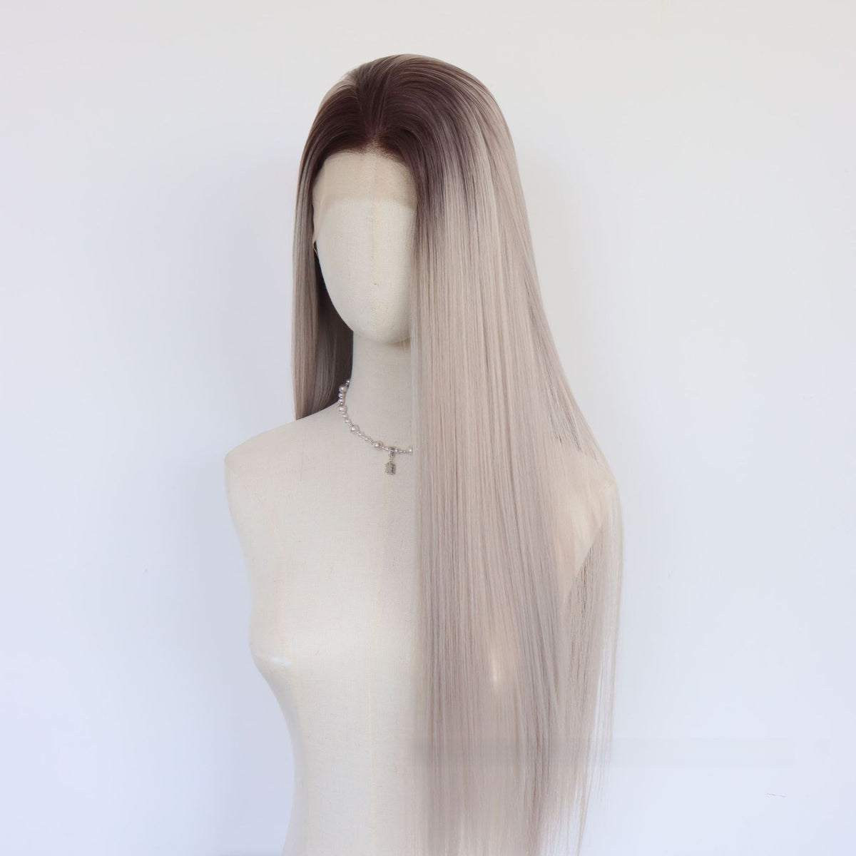 Side view of a long straight gray ombre lace front wig with dark brown roots on a mannequin