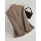 Brown herringbone tweed blazer on a hanger, back view with three buttons on the cuff, black handbag beside it