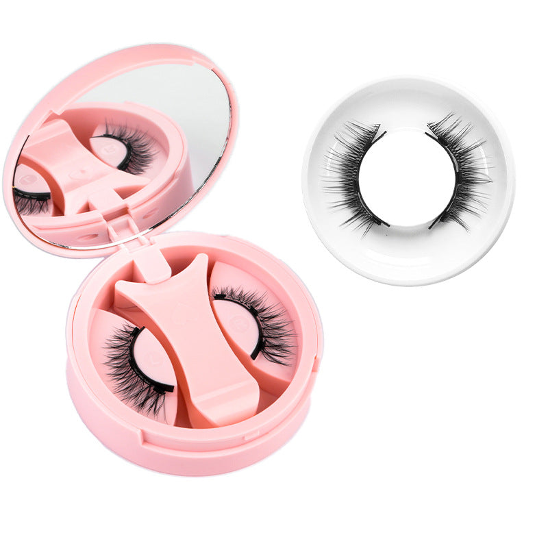 Pink round magnetic lash case open beside a single natural black lash style in a ring