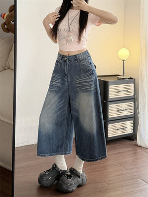 Faded blue wide-leg cropped jeans front view with whiskered hip detail