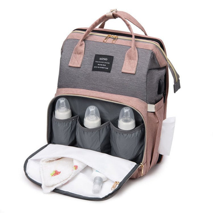 Front of the pink and gray backpack open to show three bottle sleeves and a white lined compartment with a cloth