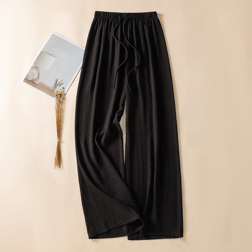 Black loose wide leg linen trousers with elastic drawstring waist laid flat