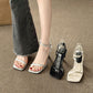 Legs in flared jeans with a silver ankle strap sandal beside black and off-white pairs on a mat