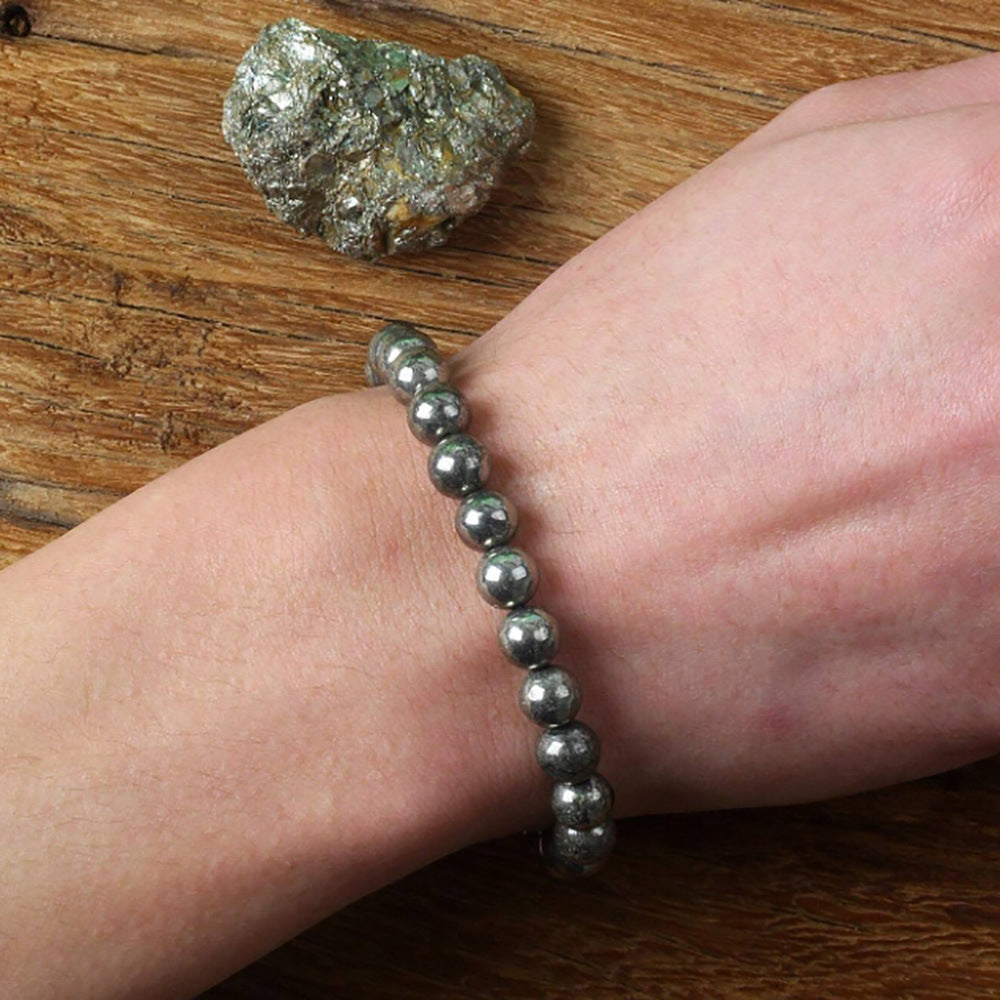 Pyrite bracelet stacked beside other beaded strands on the wrist for a layered look