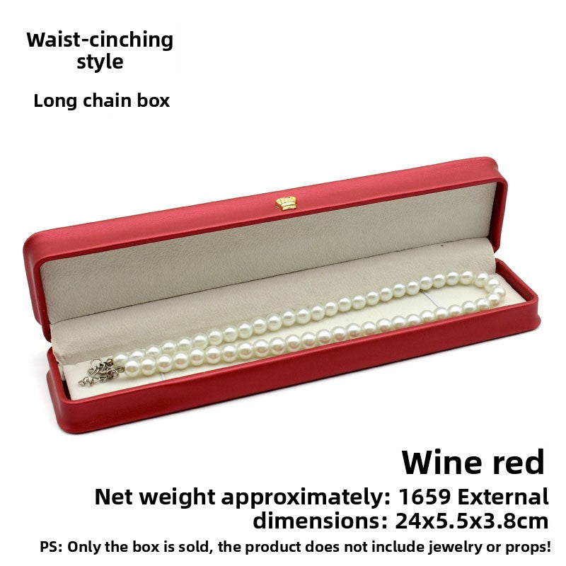 Open wine red crown clasp necklace box with a pearl necklace on the grey padded lining