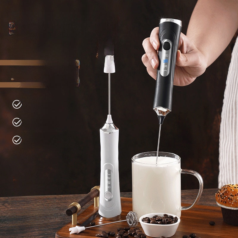 Handheld electric milk frother frothing milk into foam inside a glass mug