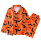 Orange pajama set with black bats and pumpkin faces on white, shirt and pants laid flat