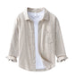 Front of the natural beige shirt layered open over a white tee on a hanger