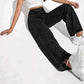 Hands tucking a tee into the high waistband of the jeans