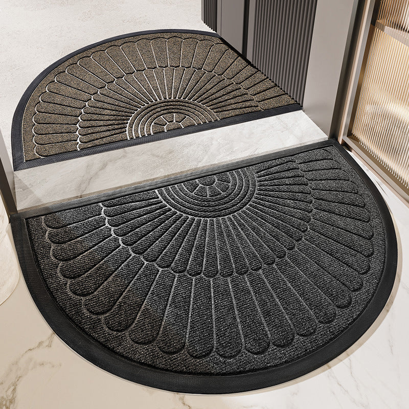 Two semi circular fan relief entrance door mats in tan and dark gray at a marble threshold