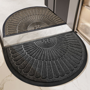 Two semi circular fan relief entrance door mats in tan and dark gray at a marble threshold