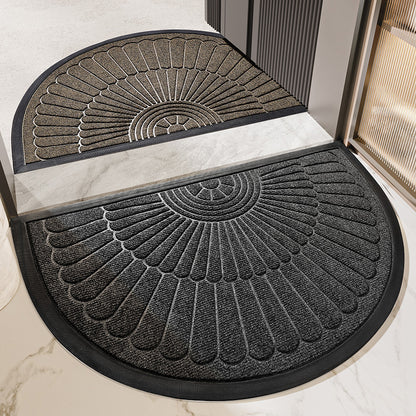 Two semi circular fan relief entrance door mats in tan and dark gray at a marble threshold