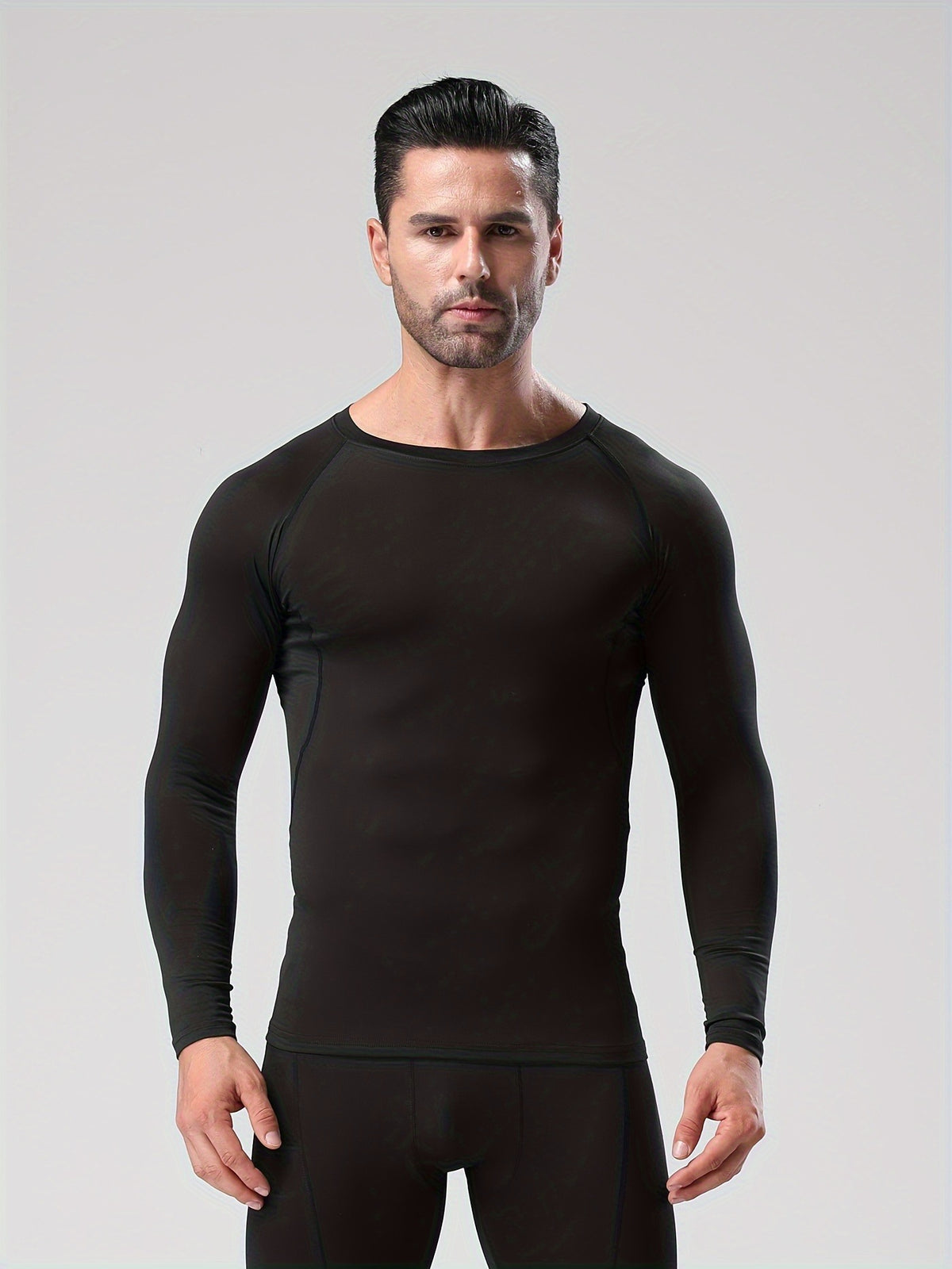 Man in a black long sleeve compression shirt with raglan sleeves, facing the camera