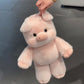 Soft plush animal toy placed on a bed next to everyday bedroom items