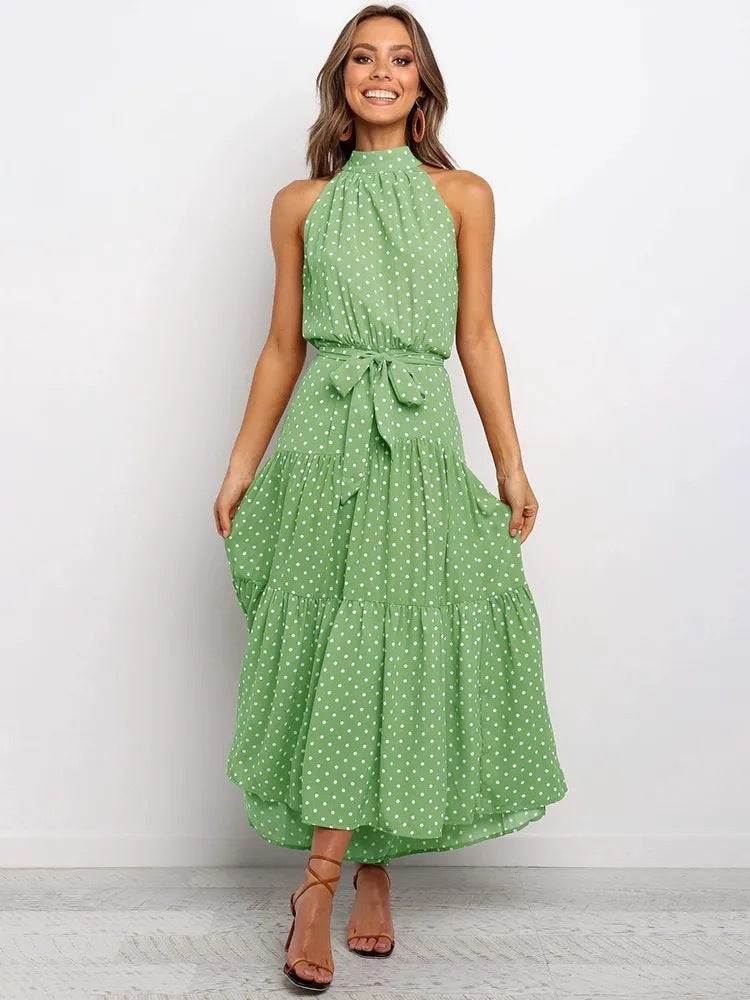 Green polka dot halter neck sleeveless tiered swing maxi dress worn by a model