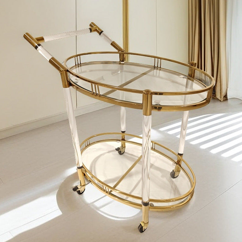 Gold stainless steel two tier serving cart with oval glass shelves and clear acrylic legs