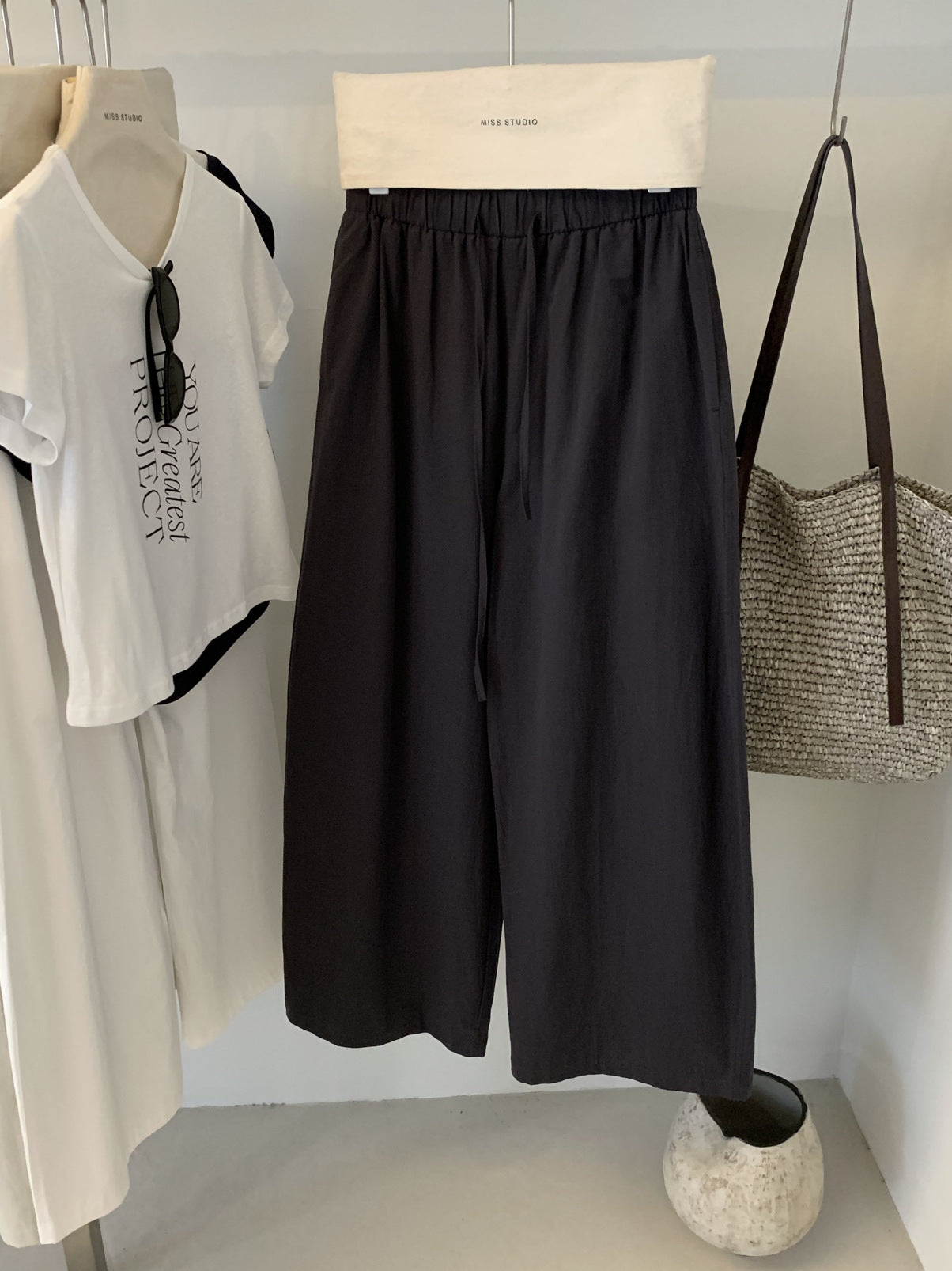 Carbon ash cotton wide leg trousers with drawstring waist on a hanger