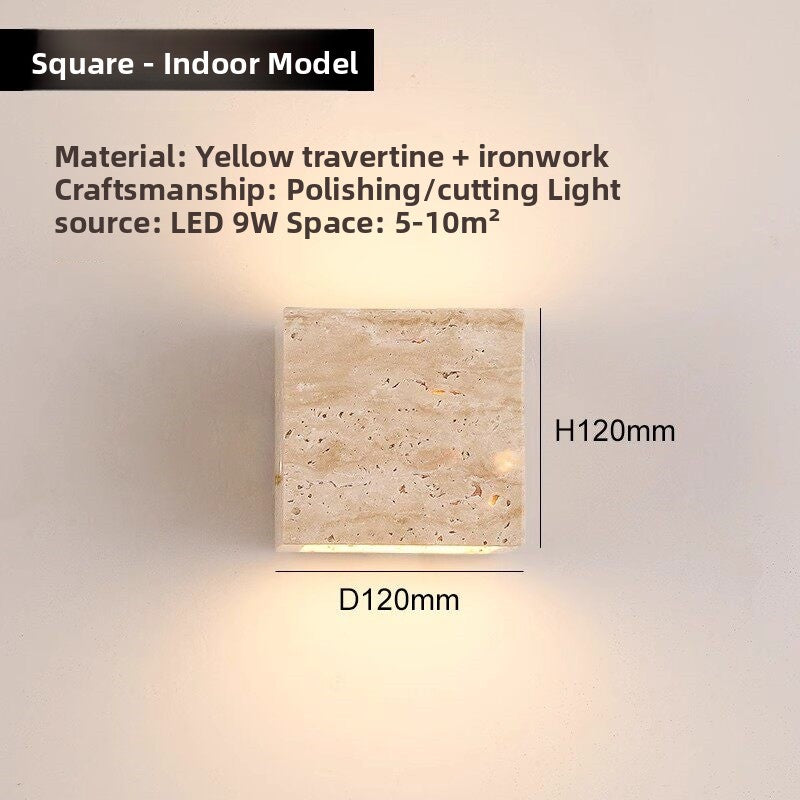 Iron framed travertine wall light glowing beside a wooden shelf at night