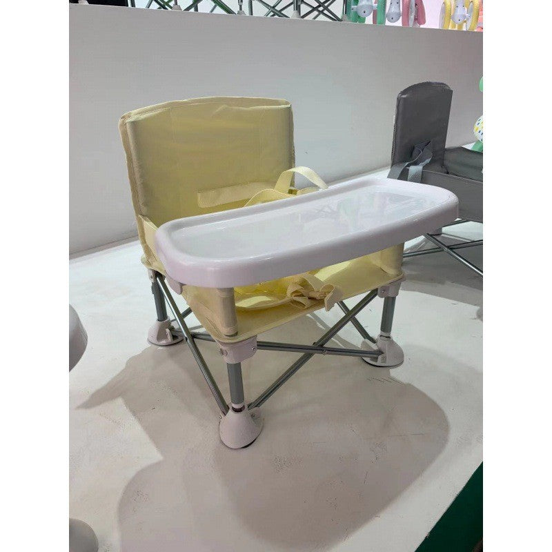 Pale yellow folding baby feeding chair without canopy, photographed in a showroom