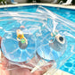 Clear squishy toy cubes with pool swimmers floating in a real pool