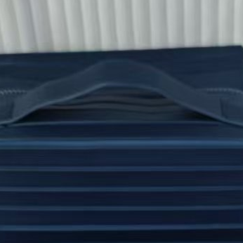 Ribbed stripe makeup organizer bag with a top handle and wrap around zip on a plain background