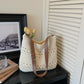 Off-white woven cotton bag styled on a table with tulips