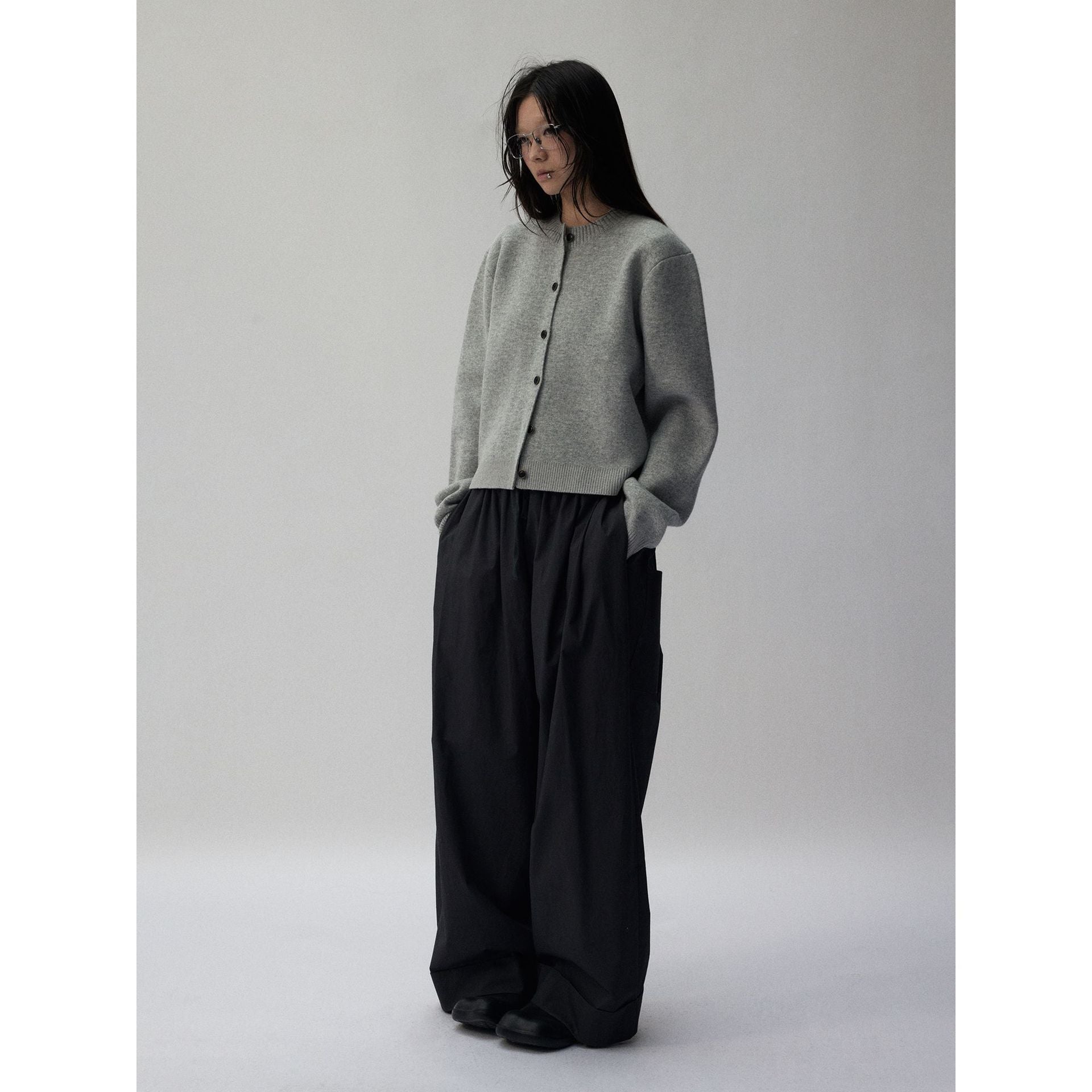 Back view of the cropped knit cardigan showing the ribbed hem
