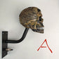 Painted resin skull finish on a metal wall rack for hanging a motorcycle helmet