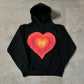 Black pullover hoodie with a hand painted Home Sick heart printed across the chest