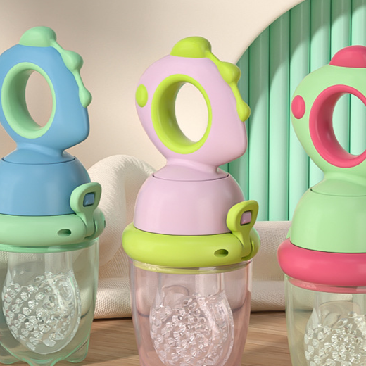 Infant holding the dinosaur fresh food feeder by the ring handle while gumming the pouch