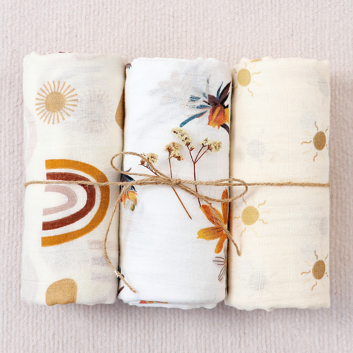 Large cotton muslin gauze baby blanket laid out, showing the loose breathable weave and print