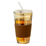 Glass straw cup filled with cold brew on a sunlit desk