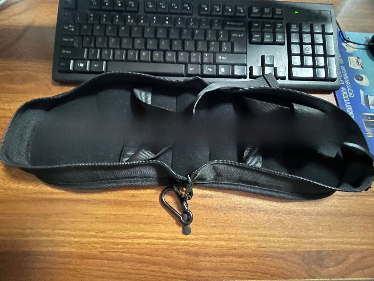 Black zippered travel pillow opened to show its inner channels, with a small clip on the zip pull, Pillow New option