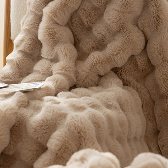 Soft ruched throw blanket in a neutral shade with a plush pile catching the light