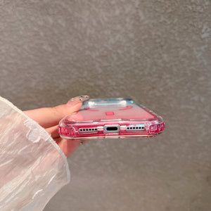 Bottom edge of a pink gradient clear case, speaker cutouts and charging port opening in view