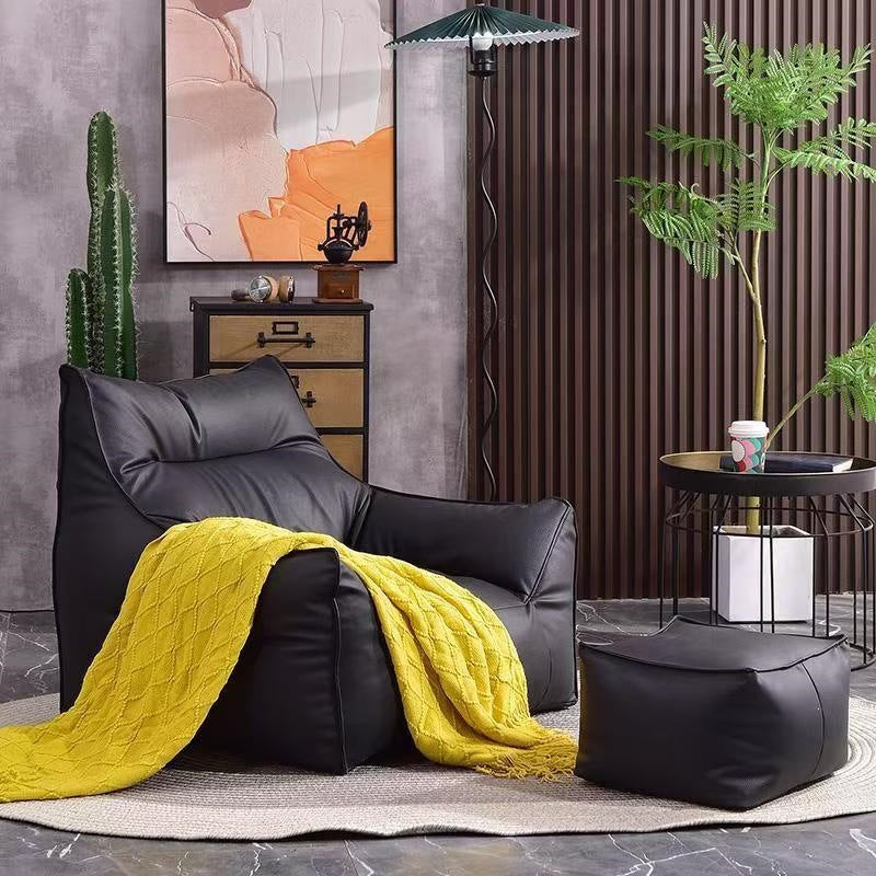 Black bean bag armchair and footstool with a yellow knit throw in a styled reading corner