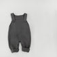 Soft focus lifestyle hero of the knit baby dungarees in a nursery