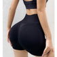Black seamless yoga shorts seen from behind, wide high waistband sitting above the navel