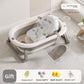 Baby bathtub with printed floating mat and a gray bath net lying beside it on the floor