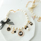 Faux pearl beaded pet necklace with a bow cameo pendant and a small jingle bell near the clasp