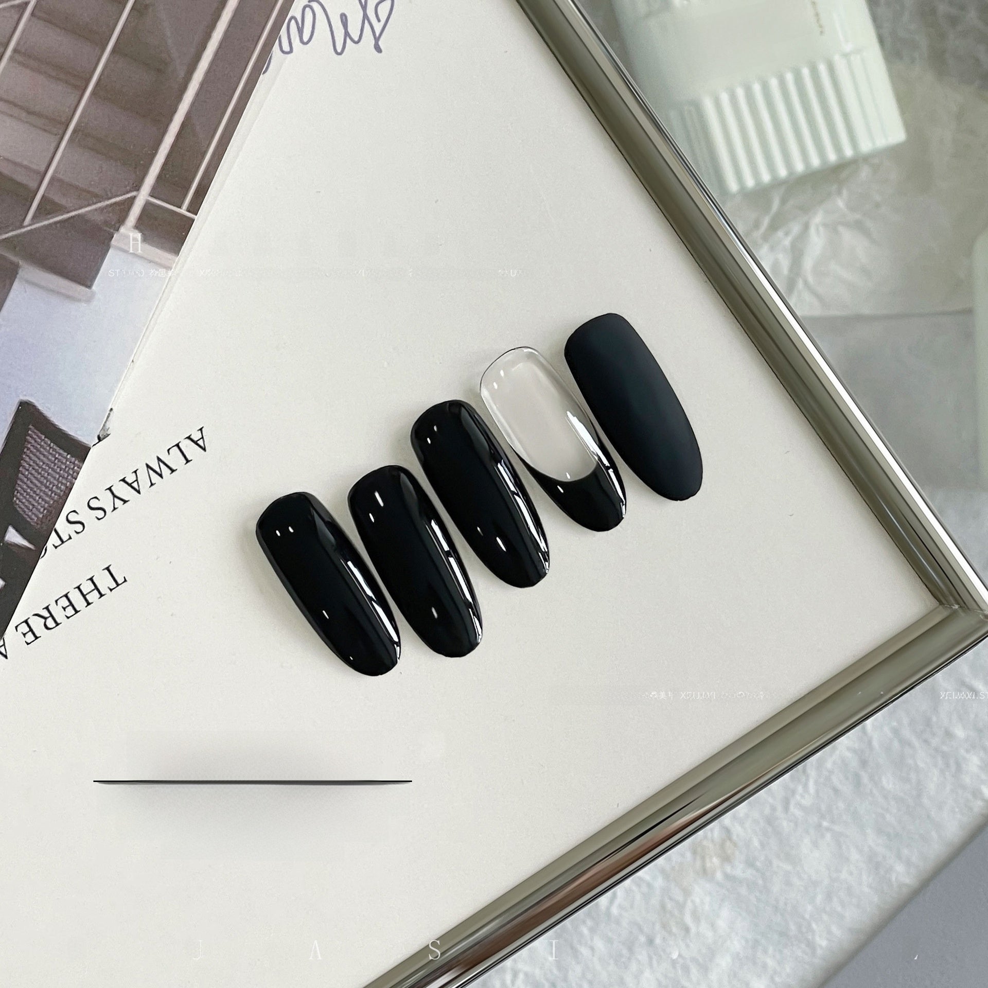 Overhead view of black and white glossy nail swatches on a tray