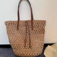 Natural straw tote bag photographed in soft studio light against a plain backdrop