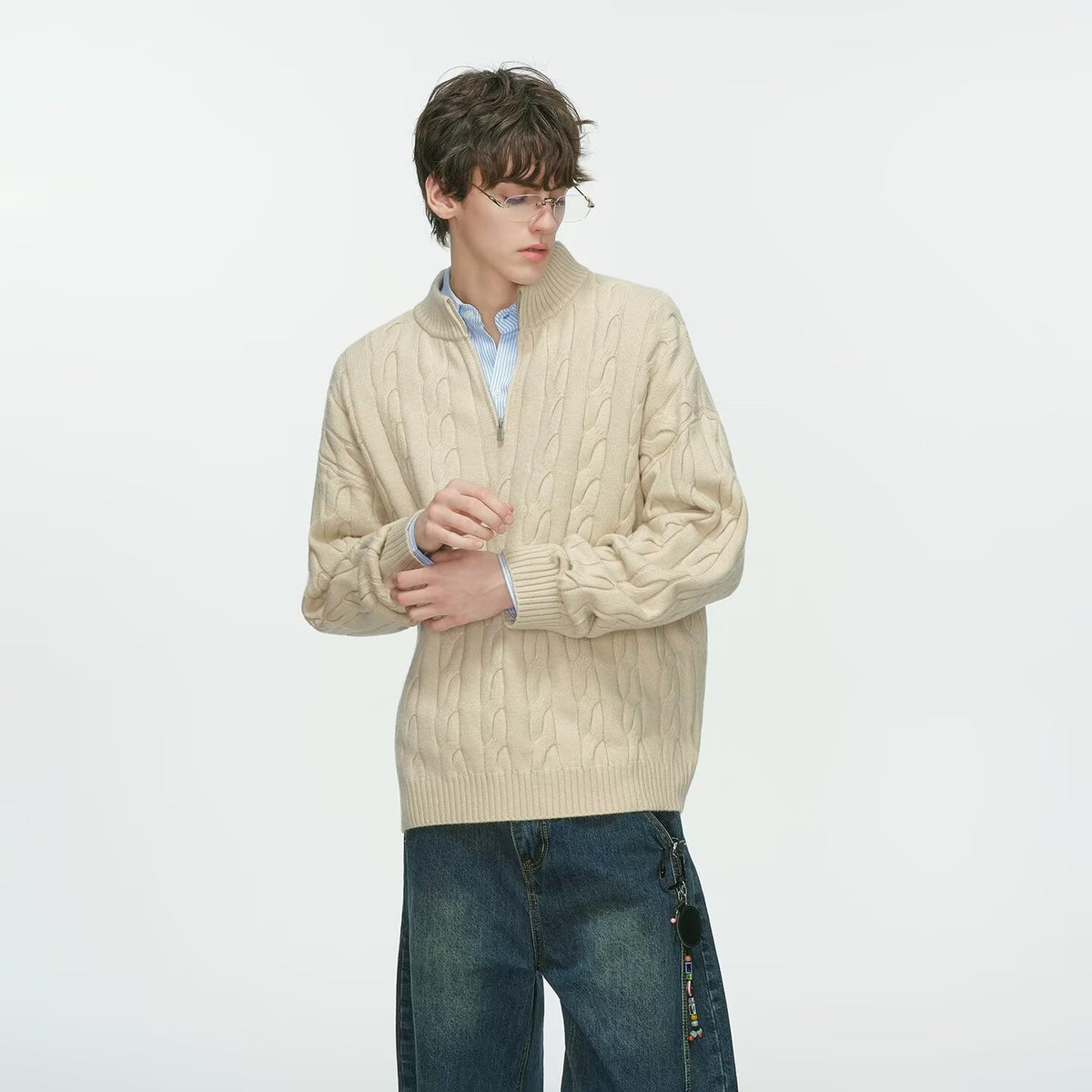 Beige khaki half zip cable knit sweater over a light blue shirt on a male model looking down, fifth khaki option photo