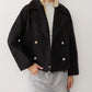 Black short double breasted wool coat worn open over a knit and grey shorts