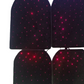 Four black car floor mats glowing with red and pink star-like points of light on a dark background