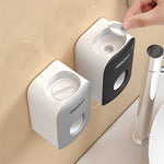 Gray and black QNEST wall toothpaste dispensers with the ridged roller insert lifted from the front opening