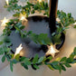 Star LED fairy string light on a green leaf vine with a warm glow, decorative photo