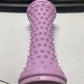 Purple nubbed foot roller standing upright on a desk beside a keyboard