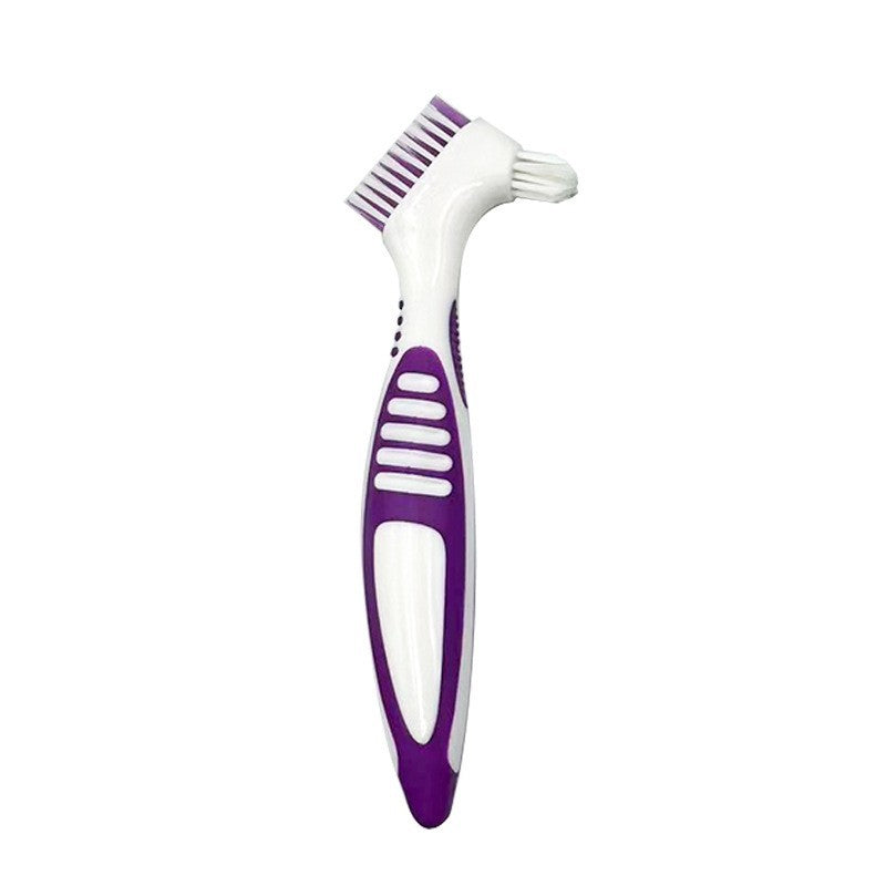 Purple double headed denture brush with a white PP handle and soft TPE grip standing upright on white