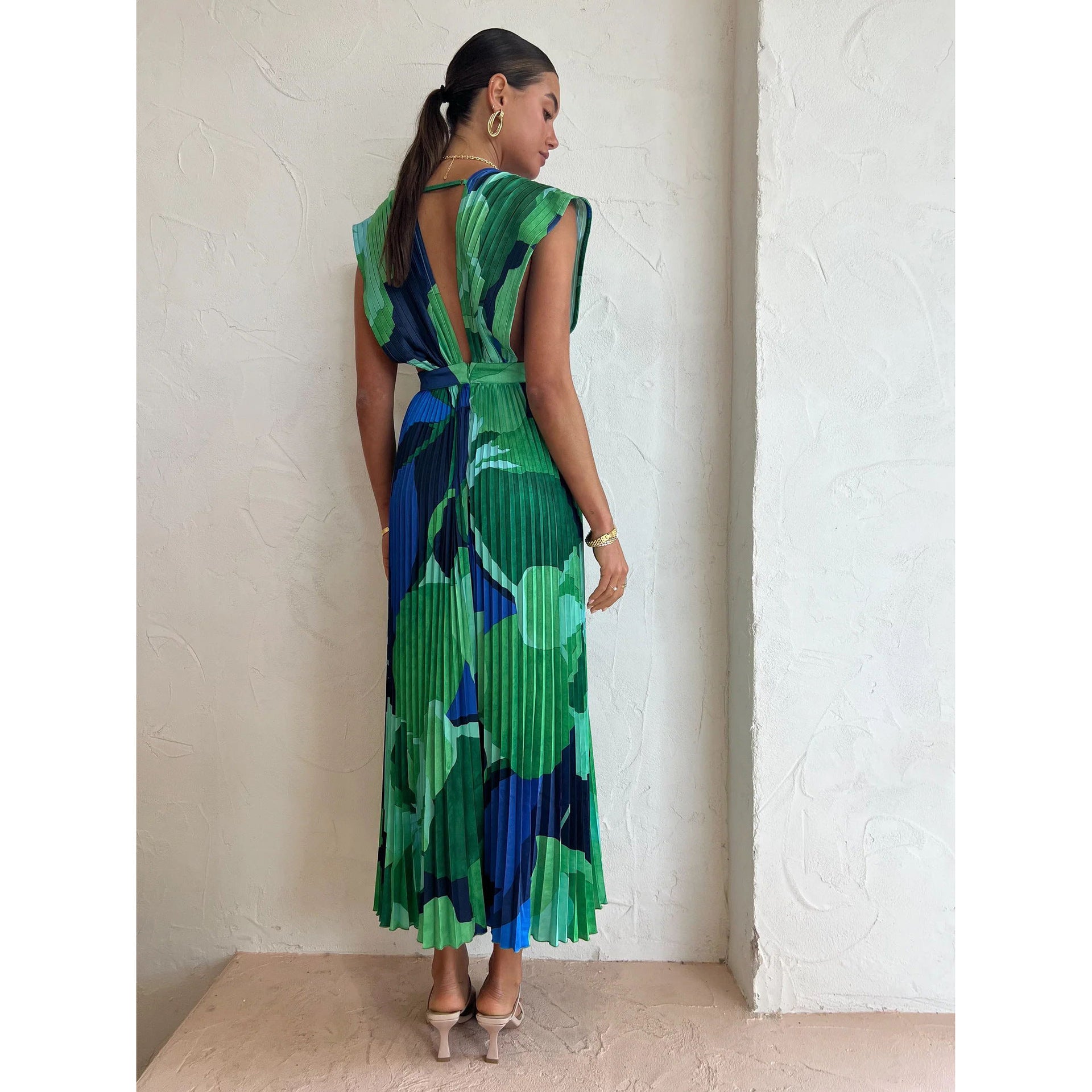 Model in the green abstract pleated maxi dress seen from the side